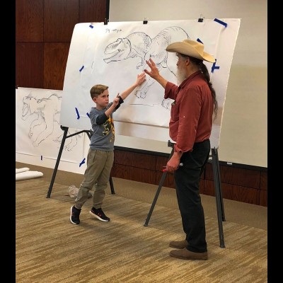 Dr. Bob appears to be debating a young man on how to draw a Tyrannosaur at the Houston Museum of Natural Science.&nbsp;&nbsp;