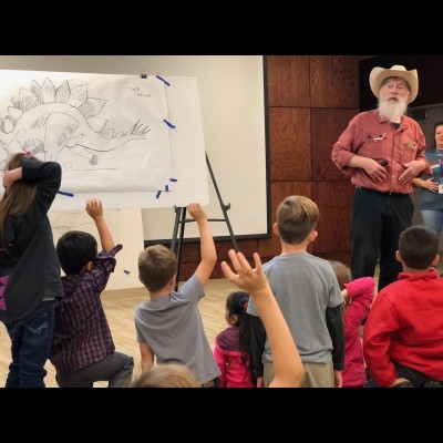 Bob taking questions about dinosaurs from a very enthusiastic crowd of kids.