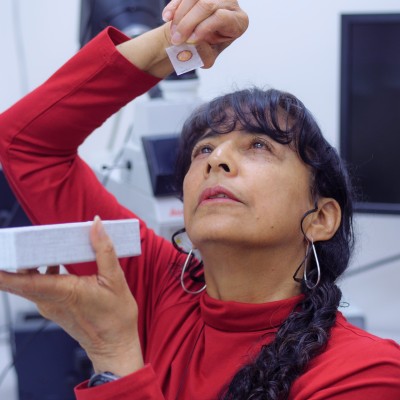 Examining a thin section at her laboratory at the University of Colorado Boulder.&nbsp; Photo credit Glenn Asakawa/University of Colorado.