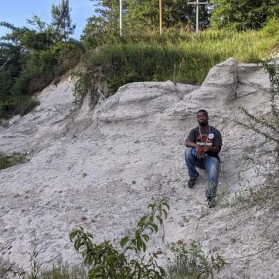 Sitting on an outcrop of Late Cretaceous Prairie Bluff Chalk in Sumter County, Alabama, 2020.
