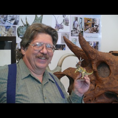 Jim and a scale model toy of Diabloceratops, one of several dinosaurs Jim has named.