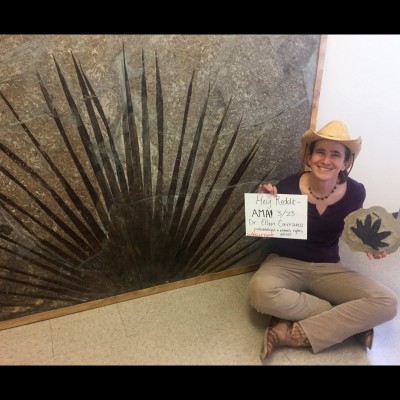 Ellen sitting next to a fossil palm frond at the University of Wyoming.