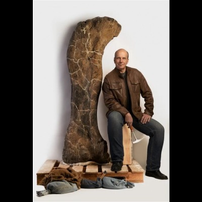 Kenneth with the 6.5 ft femur of Dreadnoughtus, the sauropod dinosaur he discovered in Patagonia. Photo by Robert Clark.