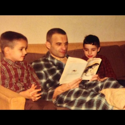 J. P. and his brother looking at a dinsoar book with their dad around 1969.