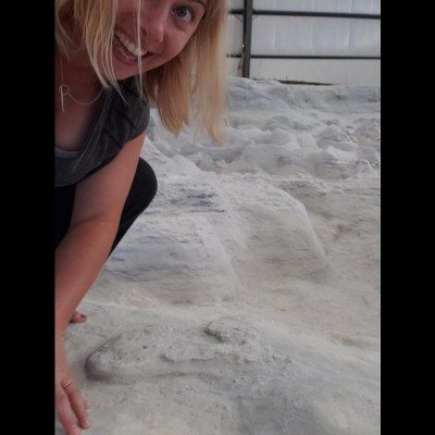 Meaghan posing with a fine pile of fossilized vomit at the Ashfall fossil site in Nebraska.