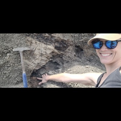 Melanie in the Mud Buttes area in North Dakota with her finger on the KPg boundary.