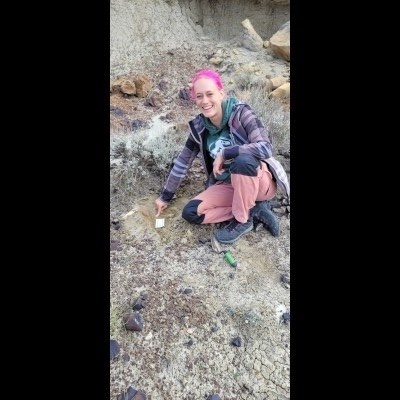 An elated Melanie in the field in North Dakota pointing at an (impossible to see here) jaw of yet unknown affinity.
